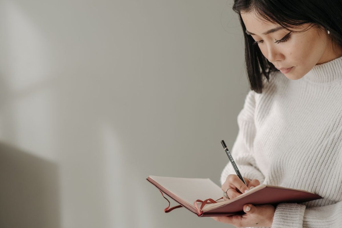 ノートに気持ちを書き出す女性