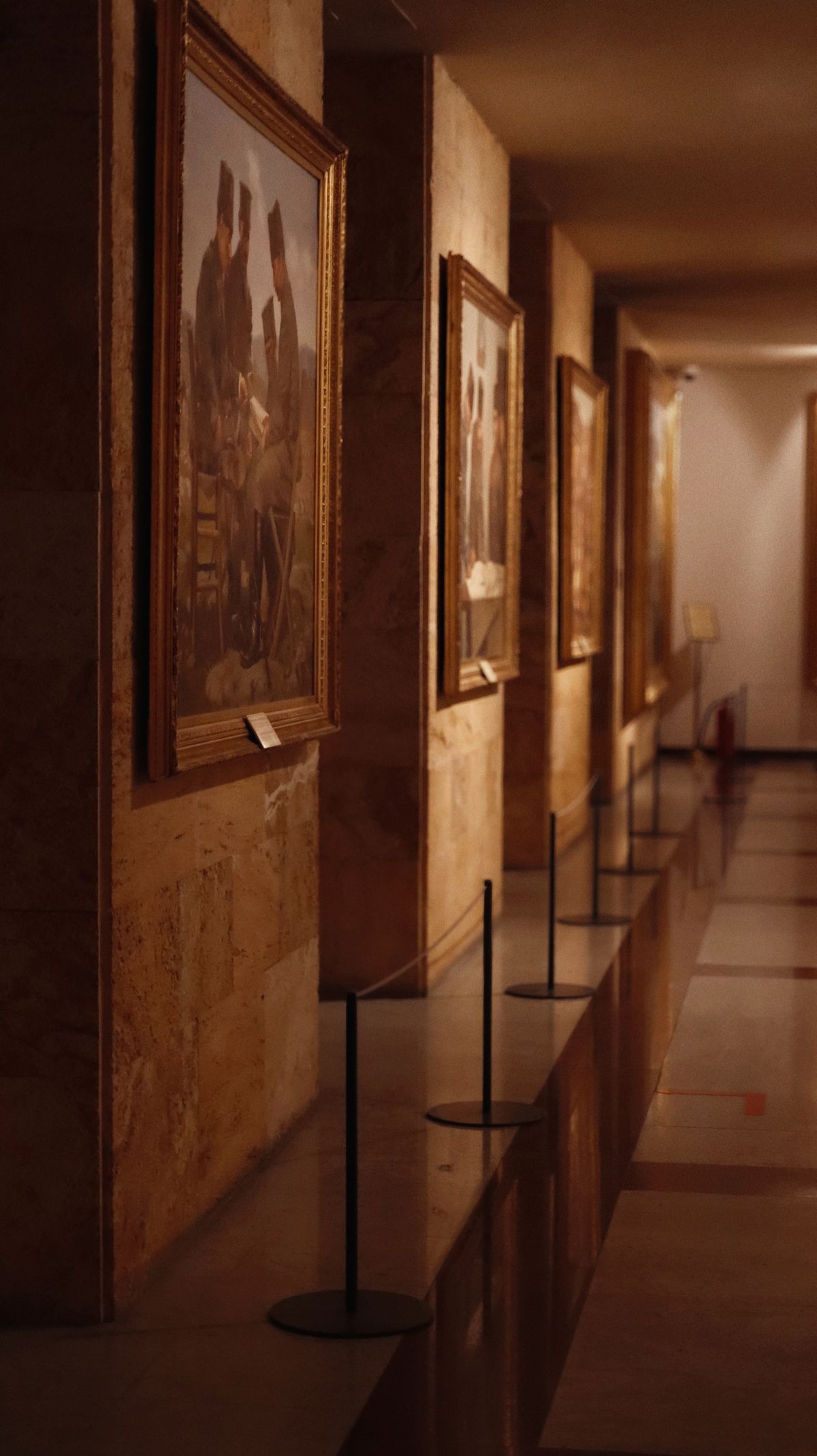絵画が並ぶ落ち着いた美術館の廊下